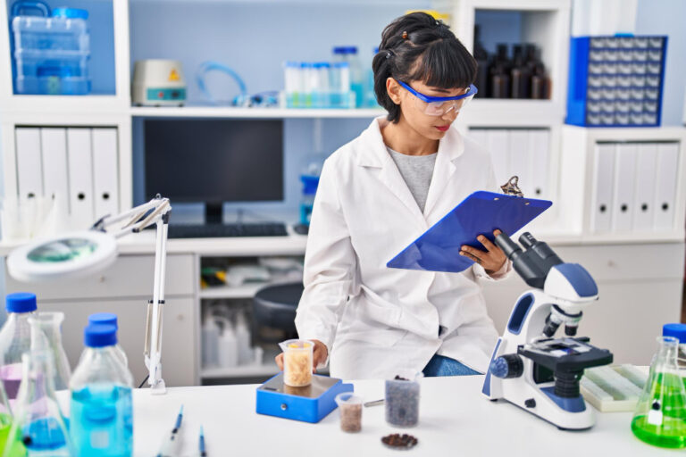 Joven científica precisamente midiendo líquido en un tubo de ensayo en el laboratorio.